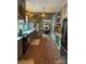 Custom kitchen boasts gray cabinets, brick floors, open shelving, and modern appliances at 324 N 5Th St, Albemarle, NC 28001