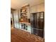Updated kitchen showcasing brick accent wall, wine storage, and modern black refrigerator at 324 N 5Th St, Albemarle, NC 28001