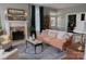 Inviting living room featuring a fireplace, hardwood floors, and large windows with elegant curtains at 324 N 5Th St, Albemarle, NC 28001