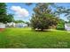 A spacious green backyard features a large tree, a black fence, and neighboring houses at 42 Linford St, Belmont, NC 28012