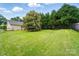A spacious green backyard features a large tree, a black fence, and the back of the house at 42 Linford St, Belmont, NC 28012