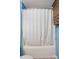 Bathroom with a shower featuring a tub, white curtain, and mounted cabinet for storage at 42 Linford St, Belmont, NC 28012