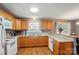 Well-lit kitchen with wood cabinets, white appliances, and wood-look floors at 42 Linford St, Belmont, NC 28012