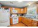 Kitchen featuring wood cabinets, white appliances, and a window over the sink at 42 Linford St, Belmont, NC 28012