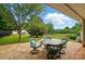 Paver patio features outdoor seating, a black fence, mature trees, and a grassy yard at 42 Linford St, Belmont, NC 28012