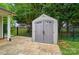 A close up of the storage shed with gray double doors on a paver patio, surrounded by a black fence at 42 Linford St, Belmont, NC 28012