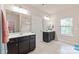 Bright bathroom with double sinks, vanity cabinets, large mirrors, and walk-in shower at 4225 Abernathy Pl, Harrisburg, NC 28075