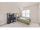 Cozy bedroom with neutral tones, bright window, and modern light fixture at 4225 Abernathy Pl, Harrisburg, NC 28075