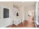 Welcoming entryway with hardwood floors, coat rack with bench, and access to other rooms in the home at 4225 Abernathy Pl, Harrisburg, NC 28075