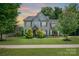 Charming two-story home with a manicured lawn, mature trees, and stone accents around the entrance at 4225 Abernathy Pl, Harrisburg, NC 28075