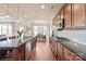 Open concept kitchen with wooden cabinets, granite countertops, stainless steel appliances, and a view into dining area at 4225 Abernathy Pl, Harrisburg, NC 28075