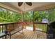 Inviting covered back porch with wood flooring, ceiling fan, bench, and view of backyard at 509 W Sixth Ave, Gastonia, NC 28052