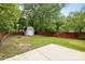Spacious backyard featuring a storage shed, patio, and ample green space enclosed by a red fence at 509 W Sixth Ave, Gastonia, NC 28052