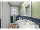 Traditional bathroom featuring a white vanity, a shower with a white curtain and navy wainscoting at 509 W Sixth Ave, Gastonia, NC 28052