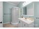 Bright bathroom with a modern vanity, a glass shower, and a decorative mirror at 509 W Sixth Ave, Gastonia, NC 28052