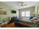 Cozy bedroom featuring a ceiling fan, a bed with a blue comforter, and a TV on the wall at 509 W Sixth Ave, Gastonia, NC 28052