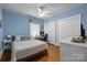 Blue bedroom with a ceiling fan, a desk, plants hanging from the ceiling and a double closet at 509 W Sixth Ave, Gastonia, NC 28052