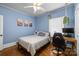 Blue bedroom with a ceiling fan, a desk, and plants hanging from the ceiling at 509 W Sixth Ave, Gastonia, NC 28052