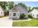 Charming gray home featuring a bay window, vinyl siding, manicured lawn and adjacent driveway at 509 W Sixth Ave, Gastonia, NC 28052