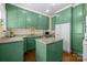 A kitchen with a kitchen island, wooden floors, granite countertops and green kitchen cabinets at 509 W Sixth Ave, Gastonia, NC 28052