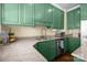Granite countertops complement green kitchen cabinets with wooden floors and stainless steel dishwasher at 509 W Sixth Ave, Gastonia, NC 28052