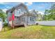 Spacious backyard with a well-maintained lawn, wooden deck, and white privacy fence at 5210 Kelly St, Charlotte, NC 28205