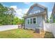 Home's backyard featuring a well-maintained lawn, deck, and privacy fence at 5210 Kelly St, Charlotte, NC 28205