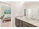 Bathroom featuring double sinks, granite countertop, and a view into the attached bedroom with a walk-in closet at 5210 Kelly St, Charlotte, NC 28205
