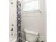 Clean and simple bathroom with white tile, a shower featuring a rainfall showerhead, and a modern toilet at 5210 Kelly St, Charlotte, NC 28205