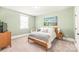 Cozy bedroom featuring a wood frame bed, soft green walls, and natural light from the window at 5210 Kelly St, Charlotte, NC 28205