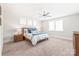 Well-lit bedroom with neutral walls, carpet, ceiling fan, and a bed with blue accents at 5210 Kelly St, Charlotte, NC 28205