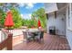 Outdoor deck with seating area, grill, and vibrant green trees surrounding the home at 5210 Kelly St, Charlotte, NC 28205