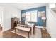 Dining room with hardwood floors, a blue accent wall, a large window, and modern light fixture at 5210 Kelly St, Charlotte, NC 28205