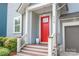 Inviting front porch with a vibrant red door, white railings, and meticulously maintained landscaping at 5210 Kelly St, Charlotte, NC 28205