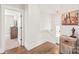 Open hallway with hardwood floors, neutral walls, doorway to bedroom, and decorative furniture at 5210 Kelly St, Charlotte, NC 28205