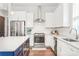 Well-equipped kitchen with a blue island, stainless steel appliances, white cabinets and subway tile backsplash at 5210 Kelly St, Charlotte, NC 28205