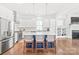 Modern kitchen features a large island with seating, stainless steel appliances, and a view into the living area at 5210 Kelly St, Charlotte, NC 28205