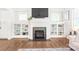 Cozy living room with fireplace, built-in shelving, a mounted TV, and hardwood flooring at 5210 Kelly St, Charlotte, NC 28205