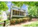 Back of house showcasing a screened porch surrounded by lush landscaping and wooded views at 5238 Downing Creek Dr, Charlotte, NC 28269