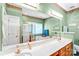 Well lit bathroom featuring double vanity, shower and tub combo, large mirror, and green walls at 5238 Downing Creek Dr, Charlotte, NC 28269