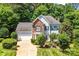 Charming two-story home with a lush lawn, mature trees, brick and blue siding, and an attached two-car garage at 5238 Downing Creek Dr, Charlotte, NC 28269