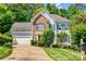 Inviting two-story home featuring brick and blue siding, a well-manicured lawn, mature trees, and an attached two-car garage at 5238 Downing Creek Dr, Charlotte, NC 28269