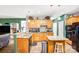 Open kitchen featuring wood cabinets, granite counters, island, and a view of the casual dining area at 5238 Downing Creek Dr, Charlotte, NC 28269