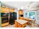 Bright eat-in kitchen with wood cabinetry, granite countertops, stainless steel appliances, and a cozy dining area at 5238 Downing Creek Dr, Charlotte, NC 28269