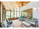 Relaxing sunroom with ample seating, ceiling fan, and stunning views of the wooded backyard at 5238 Downing Creek Dr, Charlotte, NC 28269