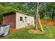 View of backyard shed, wooden fence and tree swing with a yellow ladder at 529 Dedmon Dr, Charlotte, NC 28216
