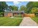 Charming brick home featuring a well-manicured lawn, mature trees, and a private driveway at 529 Dedmon Dr, Charlotte, NC 28216