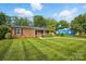 Charming brick home featuring a well-manicured lawn, mature trees, and blue neighboring home at 529 Dedmon Dr, Charlotte, NC 28216