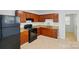 Well-lit kitchen featuring brown cabinets, granite countertops, and black appliances at 529 Dedmon Dr, Charlotte, NC 28216