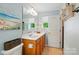 Well-lit bathroom features a vanity, toilet, and a decorative painting of the beach at 541 River Park Rd, Belmont, NC 28012
